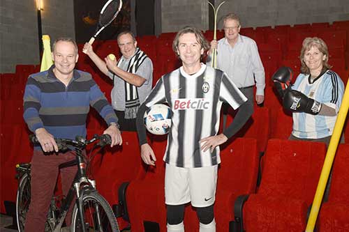 Das Volksfilmtag-Team steht mit Sportausrüstung bekleidet im Kinosaal